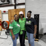 Three women posing in a warehouse
