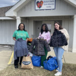 Women donating coats at child advocacy center.