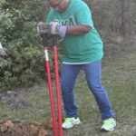 Person gardening in green and blue attire