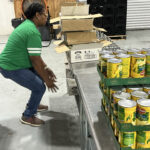 Stacking canned goods on table
