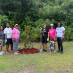 Volunteers pose by newly planted tree