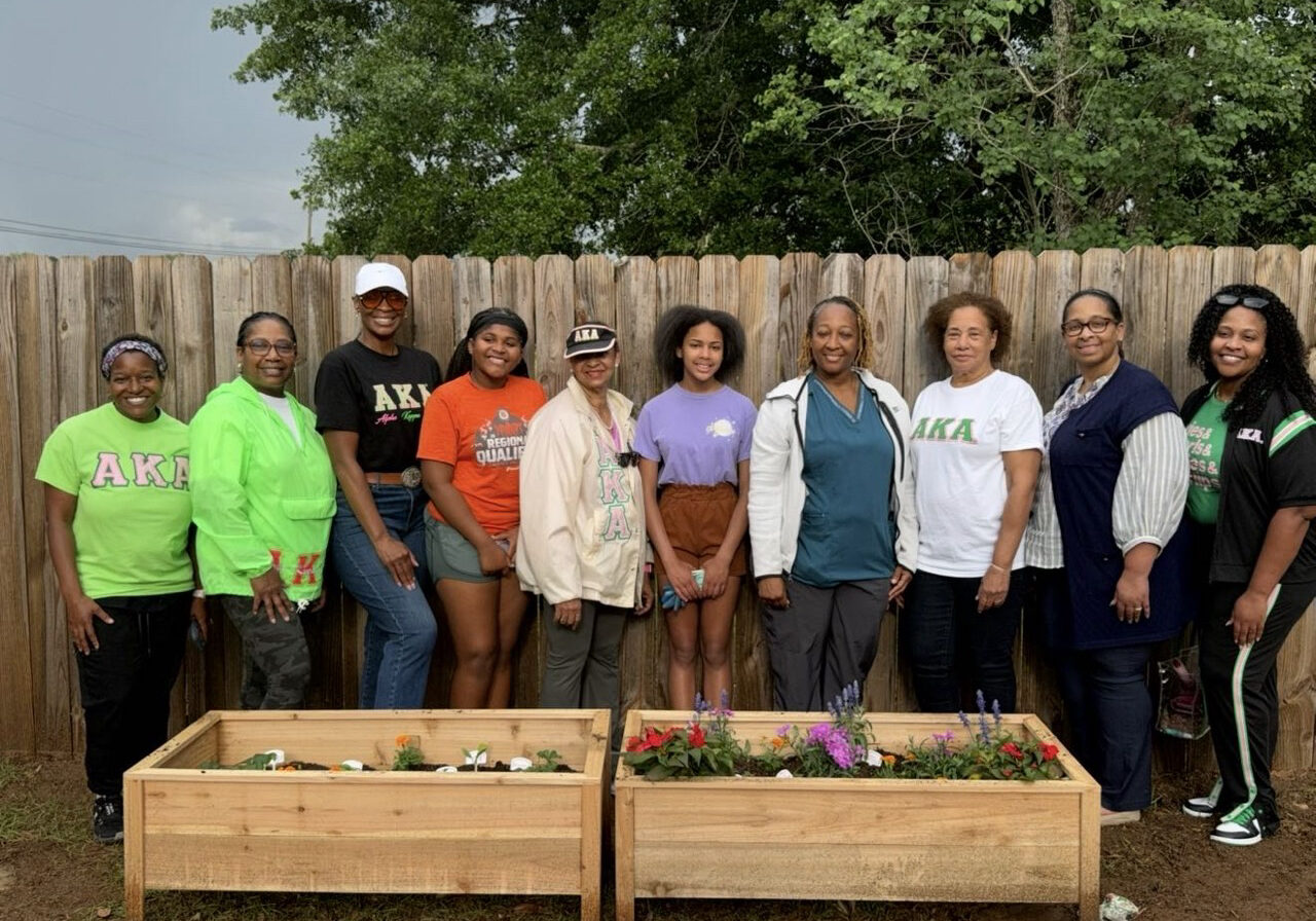 Women posing with wooden planter boxes